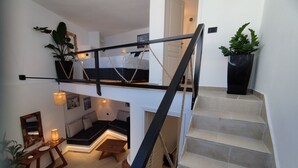 Un interior de diversos nivells amb escala, zona de dinar i espai d'estar.