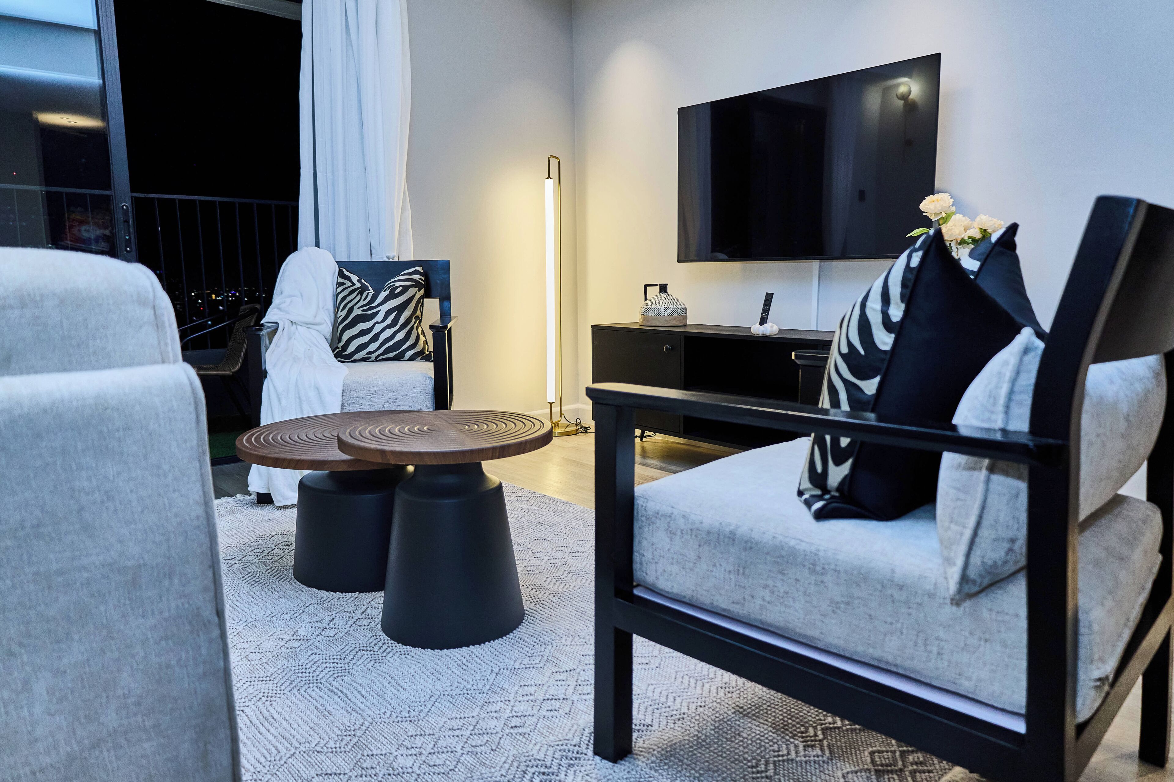 A modern living room with a sofa, a coffee table, a TV, and a floor lamp.