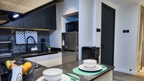 A modern kitchen with a central island, built-in appliances, and a clean layout. - Novelle By Edmor Suites (Nairobi)