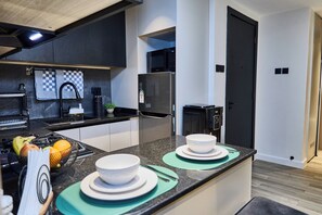 Eine moderne Küche mit einer zentralen Kochinsel, integrierten Geräten und einem aufgeräumten Design.