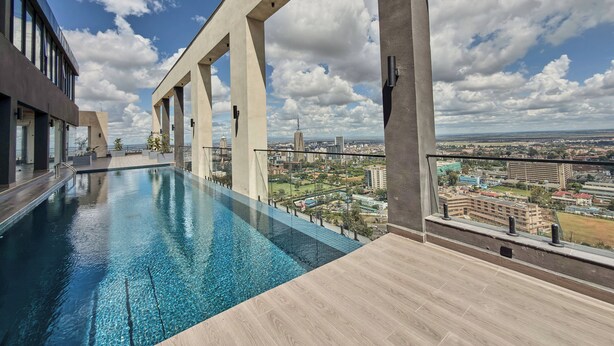 A rooftop infinity pool with a city view, supported by concrete pillars, and a clear sky. - Novelle By Edmor Suites (Nairobi)