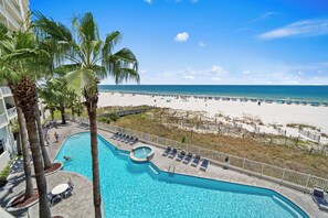 Ein Pool mit Liegestühlen, Palmen und Blick auf den Strand.