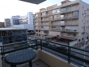 Ein mehrstöckiges Wohngebäude mit Balkonen, einem Parkplatz und im Hintergrund das Hotel 'Hotel Lyon'.