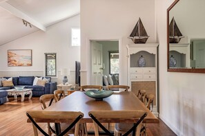 A spacious living area with a wooden dining table, blue sofa, and a large mirror. - PEACEFUL AND SERENE RURAL COTTAGE SITUATED IN QUINDALUP ON 4.5 ACRES (Quindalup)