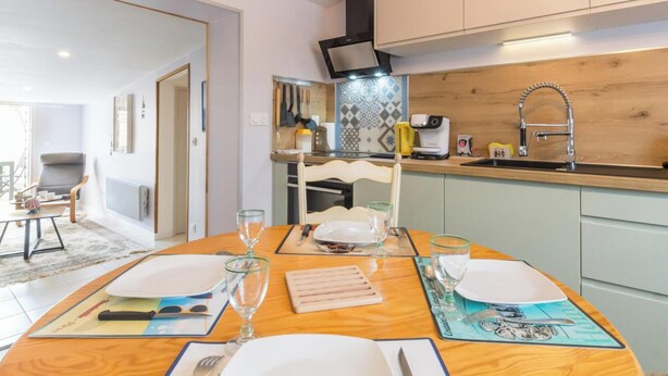 A modern kitchen with a wooden countertop, a built-in oven, and a sink with a faucet. - House near beach, AC, parking - 2 guests (Gouville-sur-Mer)