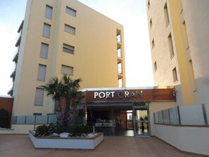 Ein Hotel Eingang mit einem Schild, das 'PORT GRAN' zeigt, und ein begrüntes Areal mit Pflanzen.