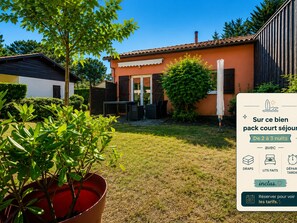 Ein Haus mit Garten und Terrasse, mit Schild, das einen Aufenthalt von 2 bis 3 Nächten inklusive Handtüchern, Betten und Frühstück anzeigt.