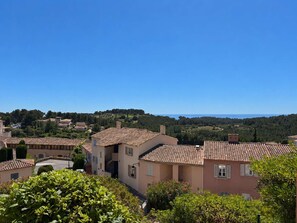 Ein Wohngebiet mit Terrakotta-Dachziegeln, blauem Himmel und üppigem Grün.