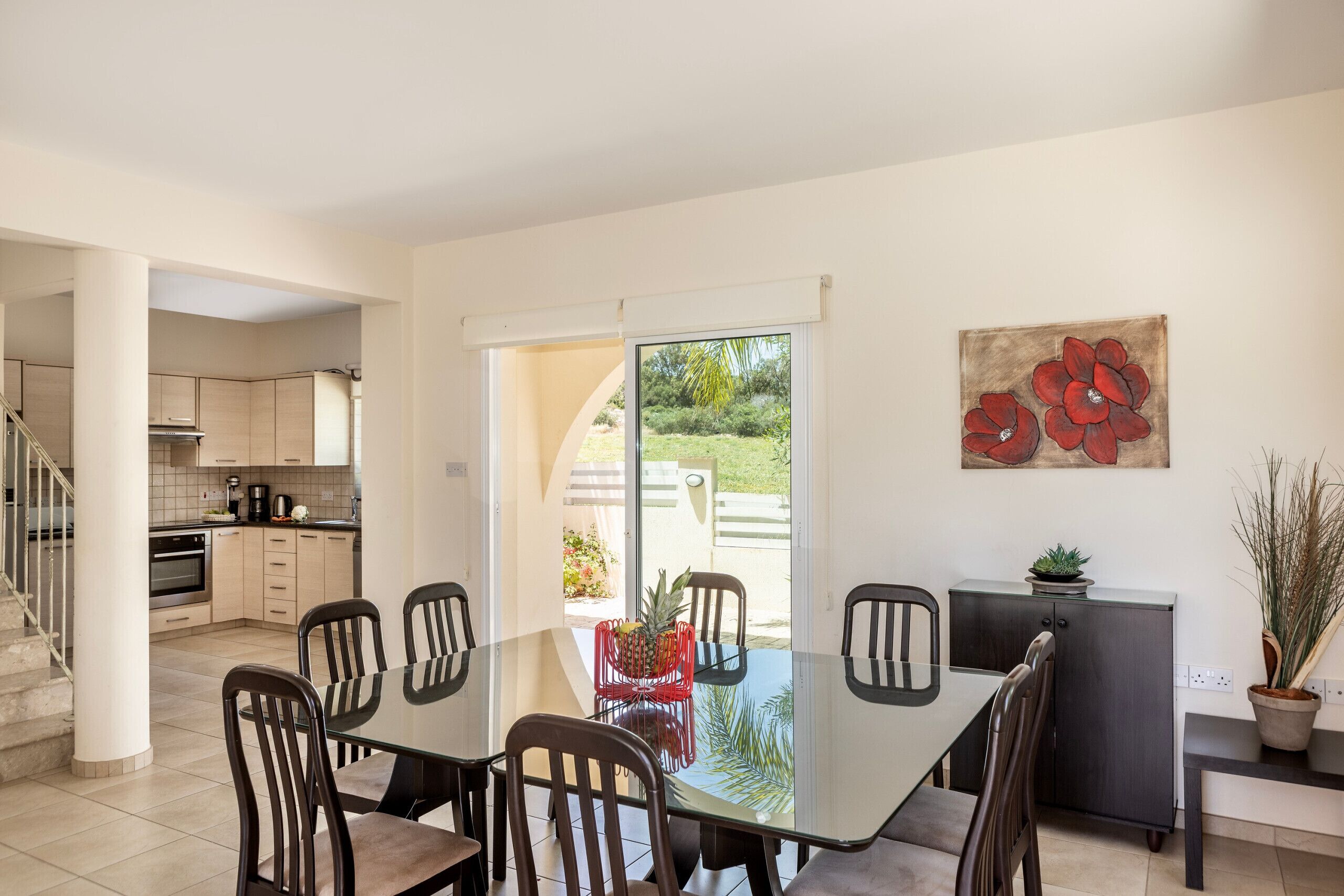 Una cocina moderna con comedor, una escalera y vistas al exterior.