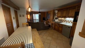 Une cuisine compacte avec une table à manger, des placards en bois et un four encastré.