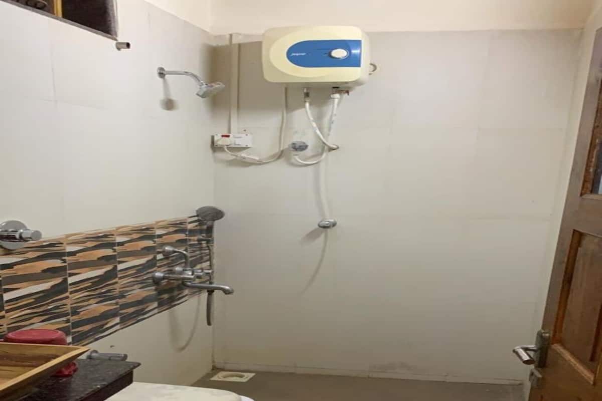 Un baño pequeño con inodoro, ducha y lavamanos.