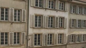Ein mehrstöckiges Gebäude mit Rundbogenfenstern und einem Ziegeldach.