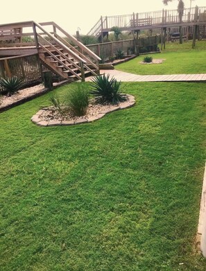 Un área verde bien cuidada con un puente y una cerca de madera.