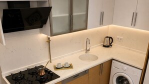 Una cocina moderna con estufa a gas, horno, lavavajillas y lavadora integrada.