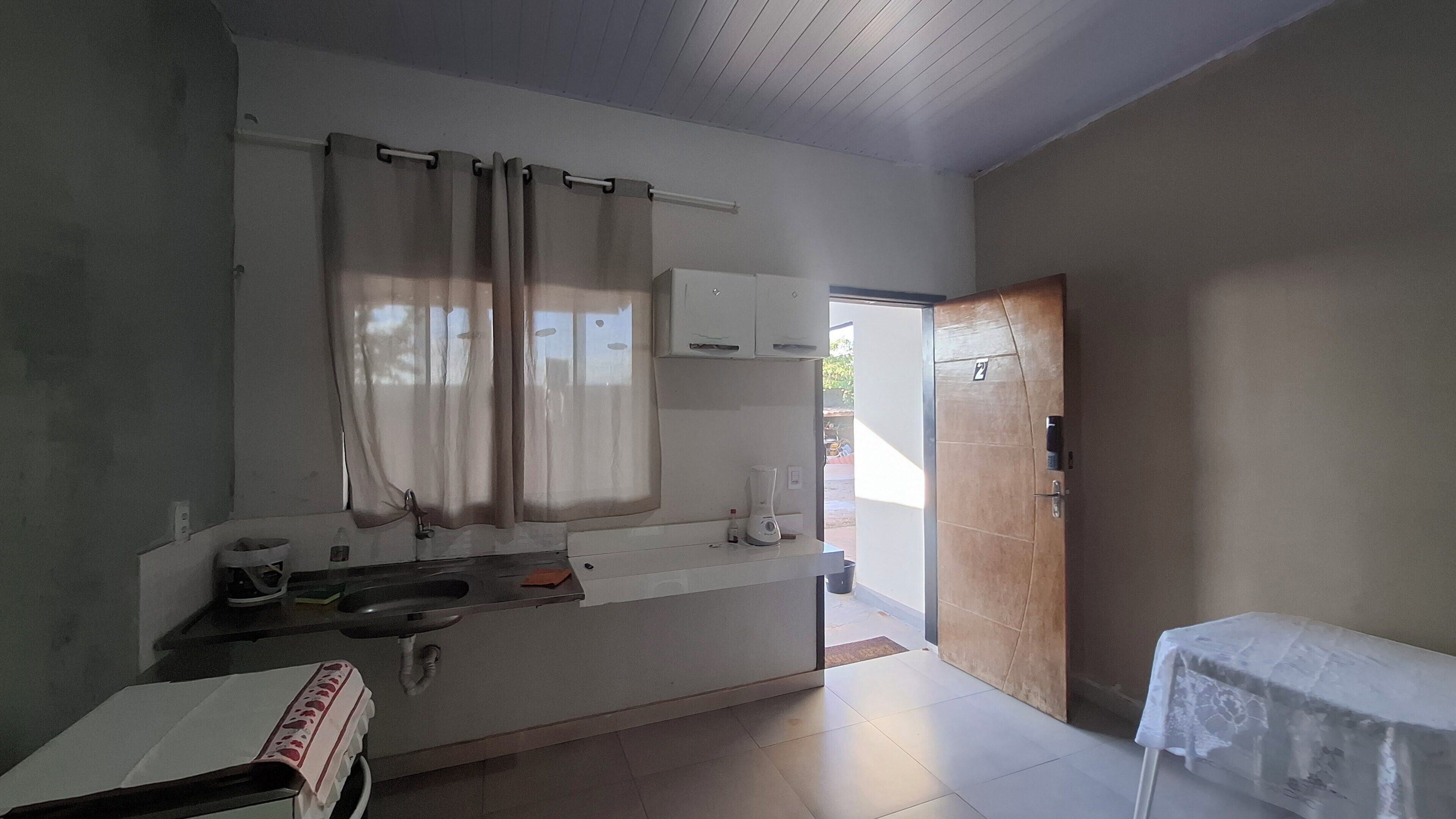 A kitchen with a window, a sink, a countertop, and a door leading outside.
