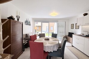 A dining area with a round table, chairs, and a view through a glass door to the outside. - Dreams of Water Nymphs, House for 6 People with Parking (Le Crotoy)