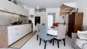 A compact living space with a kitchenette, dining area, and a sofa.