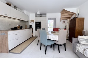 A compact living space with a kitchenette, dining area, and a sofa. - Dreams of Water Nymphs, House for 6 People with Parking (Le Crotoy)