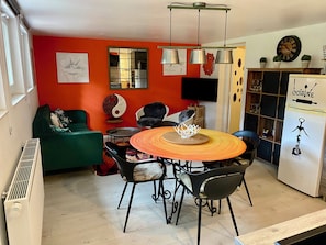 Un espace repas comprenant une table ronde, des chaises, un canapé et un réfrigérateur.
