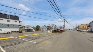 A street with buildings, a van, and parked cars. - Steps to Beach! Salisbury Family Getaway (Salisbury)