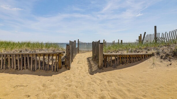A sandy beach with wooden walkways leading to the water. - Steps to Beach! Salisbury Family Getaway (Salisbury)
