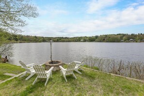 A lakeside seating area with Adirondack chairs and a fire pit. - Kayaks, Paddleboat! Lakefront Retreat in Barnstead (Center Barnstead)