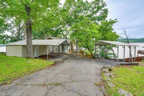 A house with a covered porch, a garage, and a view of a lake. - Dock & Lake Access! Family Escape in Osage Beach (Osage Beach)