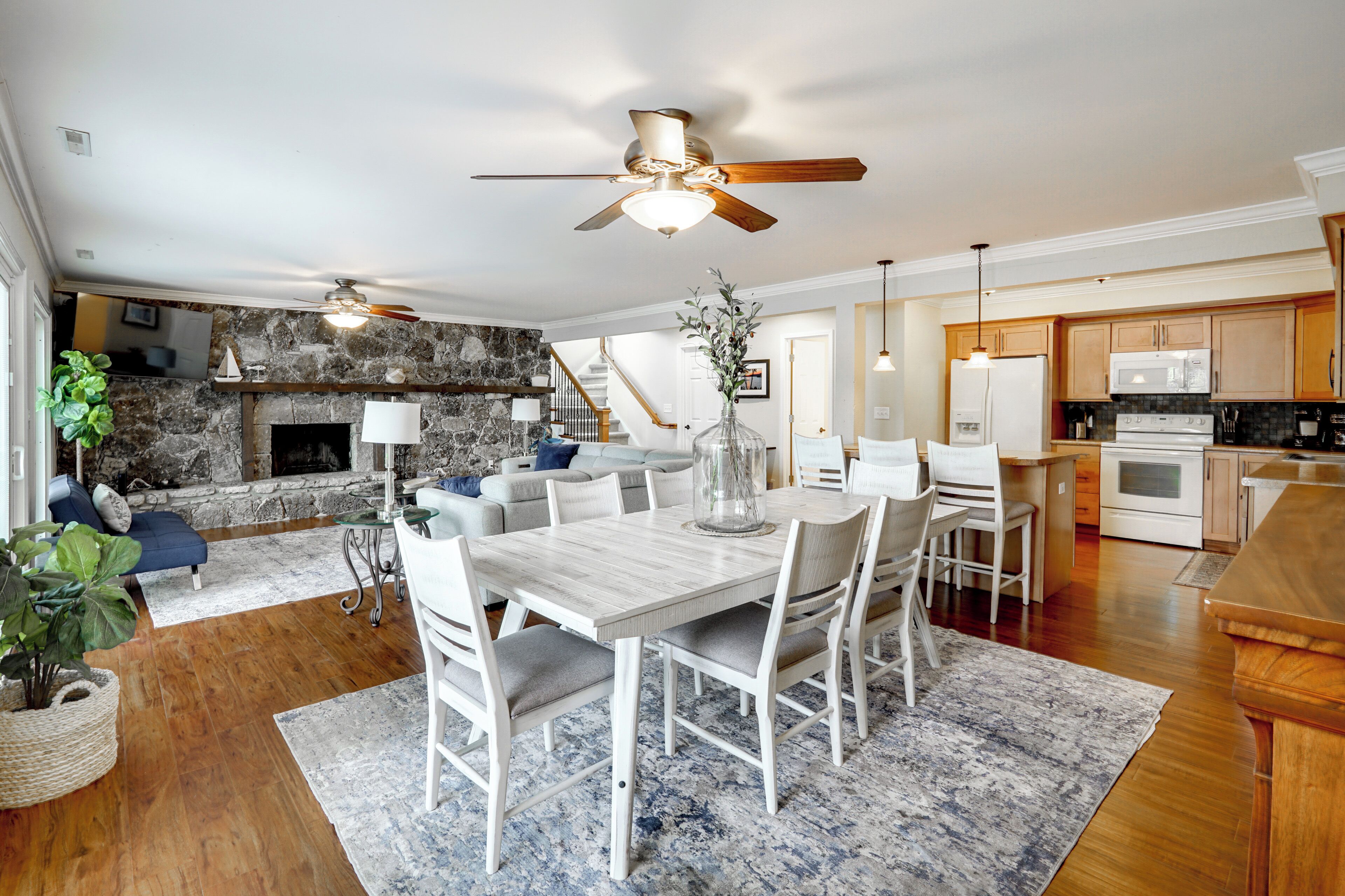 A spacious living area with a fireplace, dining table, and kitchen.