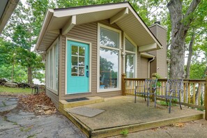 A small wooden building with a blue door, a porch with benches, and a stone pathway leading to it. - Dock & Lake Access! Family Escape in Osage Beach (Osage Beach)