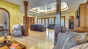 A spacious living room with hardwood floors, a fireplace, and a large window. - Stocked Pond! 33-acre Lagrange Estate w/ 2 Units (LaGrange)