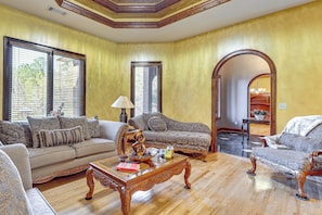 Una sala de estar con sofá, sillón, mesa de centro y chimenea.