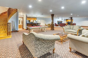 A spacious living room with a pool table, comfortable sofas, and a wooden staircase. - Stocked Pond! 33-acre Lagrange Estate w/ 2 Units (LaGrange)