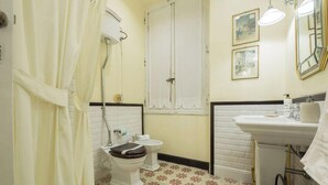 A bathroom with a toilet, bidet, sink, and a shower curtain. - The Riviera apartment, located on the ground floor of Villa Aranci in Via Fabio Filzi 2B, Genoa, offers an elegant and comfortable stay in an exclusive setting.With a private entrance, double bedroom, living area, private bathroom, and direct access to t (Genova)