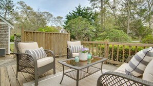 An outdoor deck with wicker furniture, a glass-top table, and a wooden fence. - 3 Mi to Nauset Beach! Family Home w/ Private Yard (Orleans)