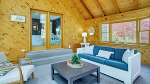 A wooden interior with a sofa, coffee table, and a staircase leading to a balcony. - 3 Mi to Nauset Beach! Family Home w/ Private Yard (Orleans)