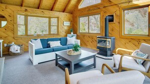 A cozy cabin interior with a wooden interior, a sofa, a coffee table, and a fireplace. - 3 Mi to Nauset Beach! Family Home w/ Private Yard (Orleans)