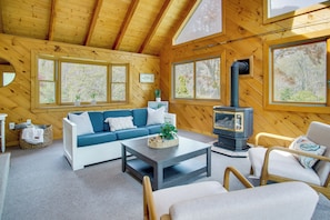 A cozy cabin interior with a wooden interior, a sofa, a coffee table, and a fireplace. - 3 Mi to Nauset Beach! Family Home w/ Private Yard (Orleans)