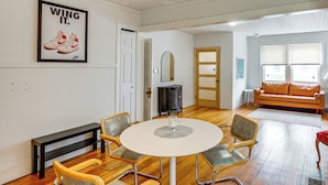 A room with a round table, four chairs, a bench, a sofa, a fireplace, and a door leading to another room. - Walk to Everything! Dtwn Hudson Apartment (Hudson)