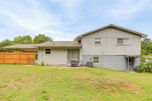 A two-story house with a covered patio, a fenced yard, and a small garden. - Easy ATL Access! Suburban Retreat w/ Yard & Patio (Riverdale)