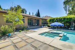 Un jardin avec une piscine, du mobilier de jardin et une maison.