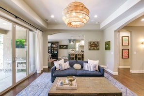 A living room with a sofa, coffee table, and a chandelier.