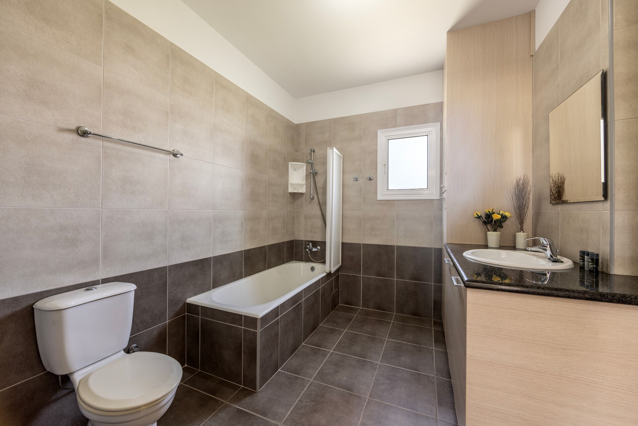A bathroom with a toilet, bathtub, and sink.