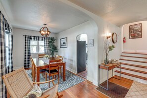 A dining area with a wooden table and chairs, a chandelier, and a patterned rug. - Walkable Family Home in the Heart of Kalispell (Kalispell)
