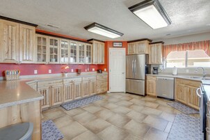 Una cocina con gabinetes de madera, un refrigerador de acero inoxidable y un horno empotrado.