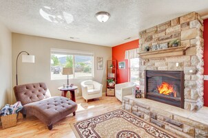 Una sala de estar con chimenea, un ventanal grande y una pared de acento roja.