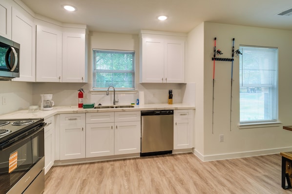 A modern kitchen with white cabinets, stainless steel appliances, and a dishwasher.