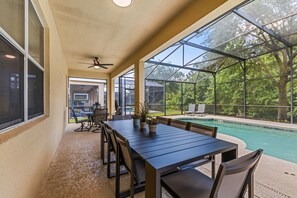 A covered patio with a pool, outdoor seating, and a ceiling fan. - Sleeps 13·Pvt Pool+Spa·Game Room·Clubhouse (Kissimmee)