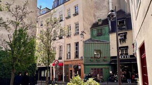 A narrow street with buildings, a no parking sign, and a cafe with outdoor seating. - Serenity :  Meditation at Notre - Dame — AC (Paris)