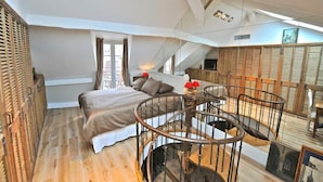 Un dormitorio con cama, una escalera circular y vistas al exterior.