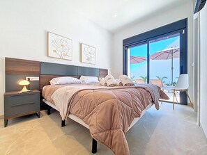 Ein modernes Schlafzimmer mit einem großen Bett, Nachttischen und Bildern an der Wand.